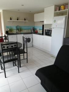 a kitchen with a table and chairs and a refrigerator at Gite Bin Benaise sans linge in Pamproux