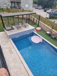 an overhead view of a swimming pool with chairs and a gazebo at Villa with Pool & Garden apartment 1 Ognjen in Tivat