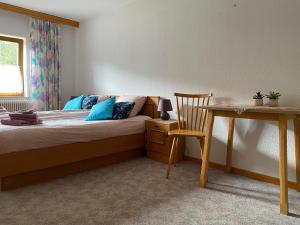 ein Schlafzimmer mit einem Bett, einem Tisch und einem Stuhl in der Unterkunft Haus Tanne Abtenau in Abtenau