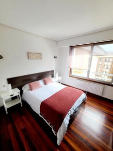 a bedroom with a large bed and a window at Apartamento Pilartxo Zarautz in Zarautz