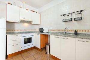 a kitchen with white cabinets and a sink at Casa Nancy in Puerto Calero