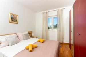 a bedroom with a bed with two stuffed animals on it at Apartment Mandalina House in Stari Grad