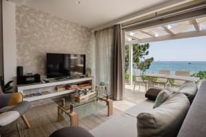 a living room with a couch and a television and a table at Addimare Sea View Villa, and Events Venue in Alykes
