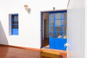 a blue door on a white building with a doorway at Casa Nancy in Puerto Calero