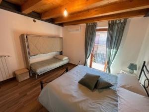 una camera da letto con un grande letto bianco e una finestra di Appartamento Il Poggetto a Montefiascone