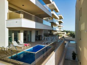 a house with a swimming pool on a balcony at Apartman DeLux with private pool in Tučepi