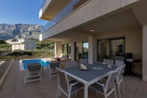 a patio with a table and chairs and a pool at Apartman DeLux with private pool in Tučepi