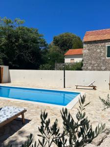 a swimming pool in front of a house at Holiday Home Hauser in Vrbanj