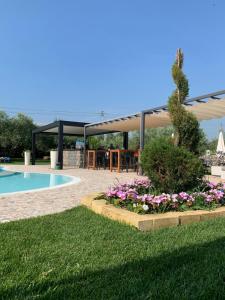 pawilon z basenem i kwiatami na dziedzińcu w obiekcie Le Mistral w mieście Sommacampagna