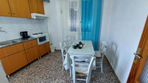 a small kitchen with a table with chairs and a microwave at Mirsini Rooms in Votsi