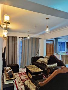 NYALI LUXURY APARTMENT في مومباسا: غرفة معيشة مع أريكة وطاولة