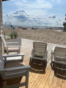 two chairs sitting on a deck at the beach at Hotel Zhong Hua in Sopot