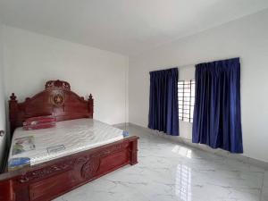 a bedroom with a bed and a window with blue curtains at 88 Apartment Sen Sok in Phnom Penh