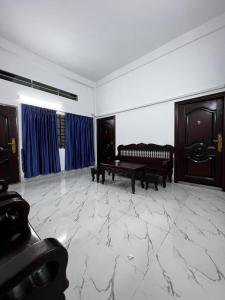 a living room with a bench and blue curtains at 88 Apartment Sen Sok in Phnom Penh