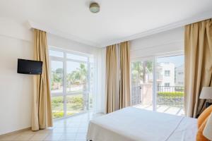 a bedroom with a bed and a large window at Apollonium Bozbuk in Akbük