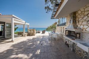 a house with a patio with the ocean in the background at Addimare Sea View Villa, and Events Venue in Alykes