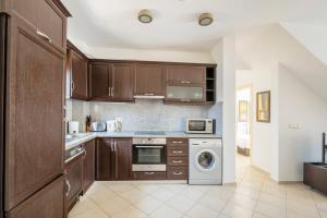a kitchen with wooden cabinets and a washer and dryer at Apollonium Bozbuk in Akbük
