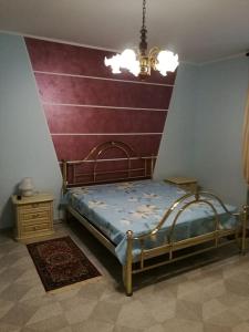 a bedroom with a bed and a red wall at Taoretto 1 in Serravalle delle Langhe