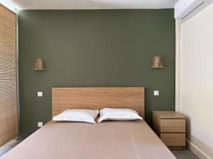 塞里尼昂"LE MARINA" Maison & Appartements proche de la mer avec piscine的一间卧室配有一张带两个白色枕头的大床