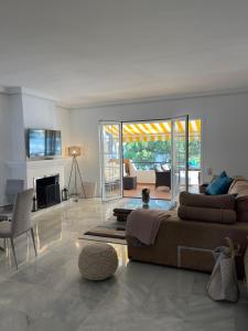 ein Wohnzimmer mit einem Sofa und einem Kamin in der Unterkunft Seaside condo with pool, Marbella in Estepona