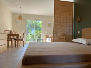 塞里尼昂"LE MARINA" Maison & Appartements proche de la mer avec piscine的一间卧室配有一张大床和一张桌子及椅子