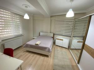 Dormitorio pequeño con cama y espejo en Charming, Quiet Flat wih a View and Working Space EYUP1, en Estambul