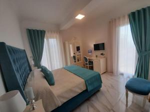 a bedroom with a large bed with green curtains and a desk at La Vigna del Vento in Casola di Napoli