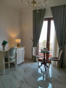 sala de estar con sillas, mesa y ventana en La Vigna del Vento en Casola di Napoli