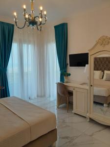 1 dormitorio con cama, escritorio y lámpara de araña en La Vigna del Vento en Casola di Napoli