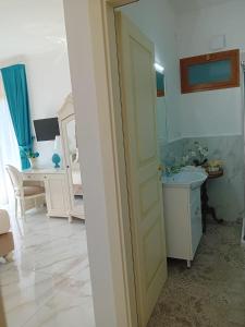 Baño blanco con lavabo y espejo en La Vigna del Vento en Casola di Napoli