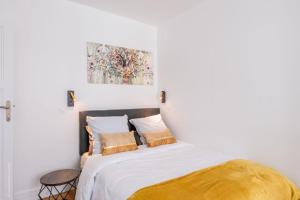 a bedroom with a bed with white sheets and pillows at Logement de standing à 18min de Paris La Défense in Colombes