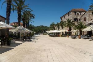 a street with tables and chairs and umbrellas at Apartment Mandalina House in Stari Grad