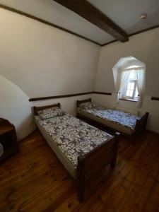 two beds in a room with a window at Готельний комплекс Трапезна in Subbotov