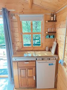 Paradise kosirina في مورتير: مطبخ في كابينة خشب مع حوض ونافذة