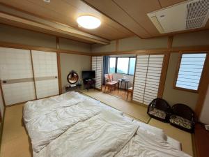 a bedroom with a large bed in a room with windows at Tsushima Dae-A Hotel in Tsushima +31 photos