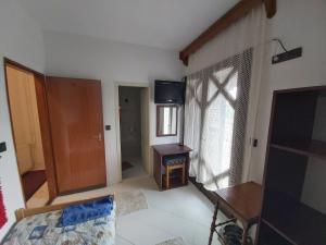 a room with a bed and a desk and a window at Valcsics Villa Panzió in Pécs