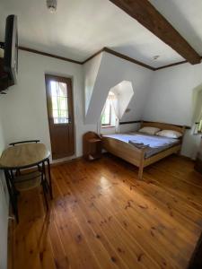 a bedroom with a bed and a wooden floor at Готельний комплекс Трапезна in Subbotov