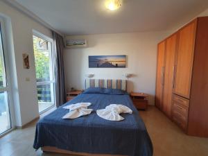 Un dormitorio con una cama azul con dos toallas encima. en Cozy, spacious apartment near Paradise Bay, en Sozopol 17 fotos más