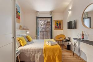 1 dormitorio con cama con almohadas amarillas y espejo en FlaViArt, en Olbia