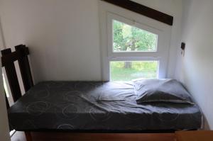 a bed in a room with a window at Black Mountain Village in Cuxac-Cabardès