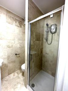 a shower stall in a bathroom with a toilet at Stylish and cozy flats in London