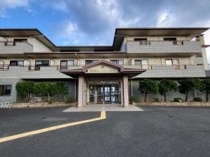 a building with a parking lot in front of it at Tsushima Dae-A Hotel in Tsushima