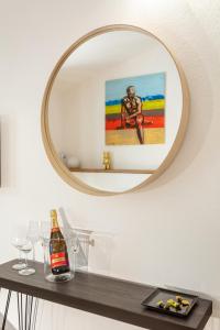 un espejo en una pared con una botella de vino en una mesa en FlaViArt, en Olbia