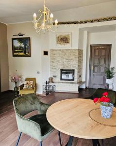 a living room with a table and a fireplace at Sodyba Pakrantė in Dituva