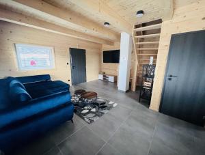 戈爾拉赫夫的住宿－Rezortík Gerlachov CHATA 1，客厅配有蓝色的沙发和平面电视。