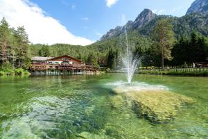 a fountain in the middle of a lake at Hotel Lago della Creta in San Vigilio Di Marebbe