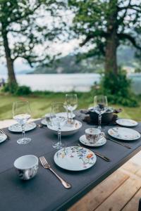 una mesa con platos y copas de vino. en Eco Lodges Millstätter See en Döbriach