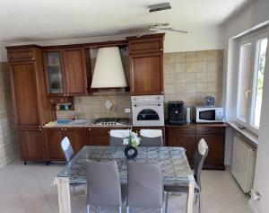 a kitchen with wooden cabinets and a table with chairs at Sole in Verbania +25 photos