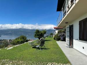 einen Balkon eines Hauses mit Stühlen auf dem Rasen in der Unterkunft Sole in Verbania