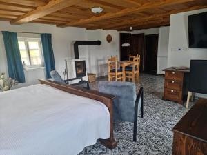 1 dormitorio con 1 cama, mesa y sillas en Luxusní apartmán s krbem - Kunratické Švýcarsko en Kunratice